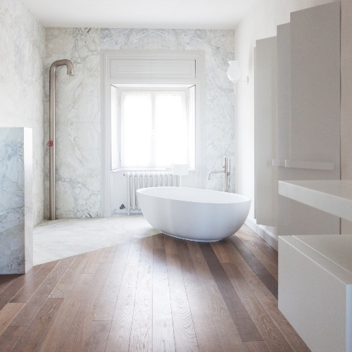 Home Wellness: vasca freestanding, parquet e rivestimento marmo bianco all'interno del bagno di Villa Gavazzeni